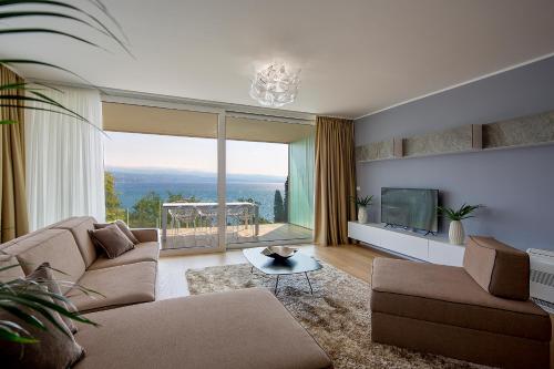 a living room with a couch and a tv at Deluxe Apartments Opatija in Opatija