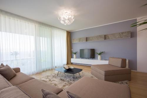 a living room with a couch and a tv at Deluxe Apartments Opatija in Opatija