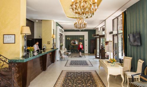 - un hall d'accueil avec un lustre et une femme dans l'établissement Premier Luxury Mountain Resort, à Bansko