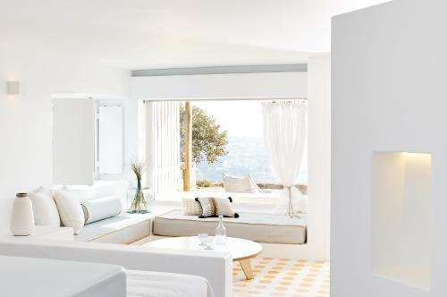 salon z białymi meblami i dużym oknem w obiekcie Amare Mykonos w mieście Tourlos