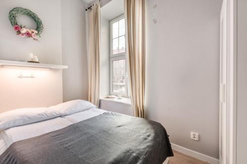 a bedroom with a bed and a window at Golden Gate by Loft Apartments in Gdańsk