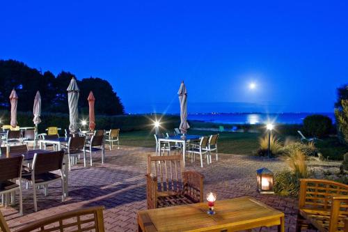 - un restaurant avec des tables et des chaises la nuit dans l'établissement Hôtel Restaurant Le Mur du Roy, à Sarzeau