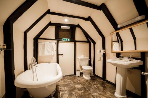 a bathroom with a tub and a sink and a toilet at Mermaid Inn in Rye