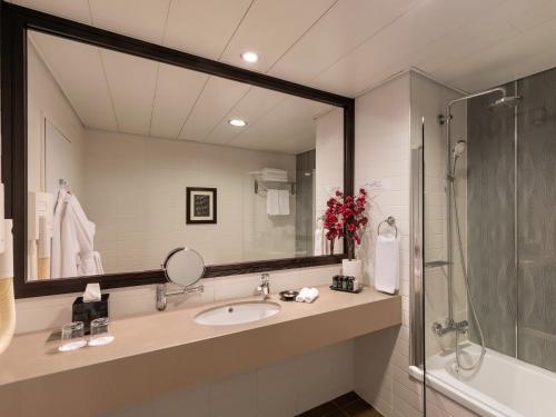 a bathroom with a sink, mirror and bath tub at Vital Hotel - Business Boutique Hotel in Tel Aviv