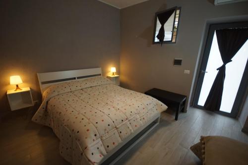 ein Schlafzimmer mit einem Bett, zwei Lampen und einem Fenster in der Unterkunft Locazione Turistica Domus Re in Agrigento