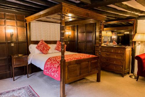 a bedroom with a canopy bed and a dresser at Mermaid Inn in Rye