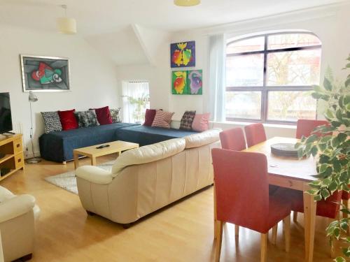 a living room with a couch and a table at 1 Fitzhamon Embankment APARTMENTS opposite Principality Stadium - free parking nearby - LONG STAY OFFER - newly redecorated March 2024 in Cardiff