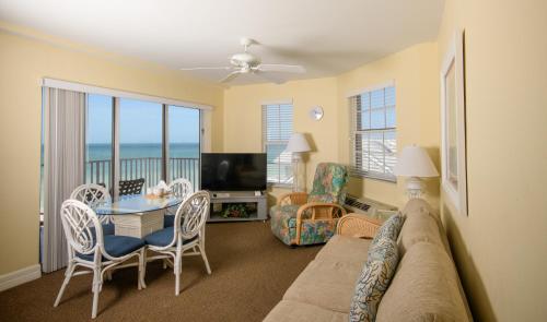 a living room with a couch and a table and chairs at Edison Beach House in Fort Myers Beach