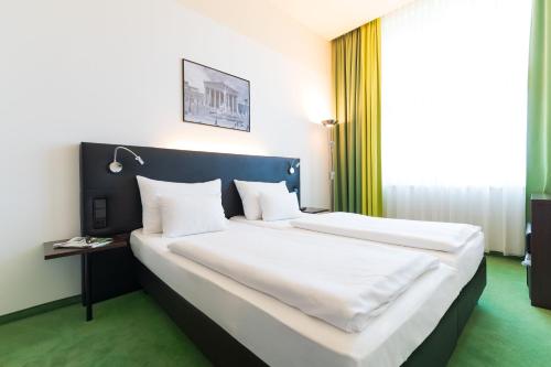 a bedroom with a large bed with white sheets and pillows at Rainers Hotel Vienna in Vienna