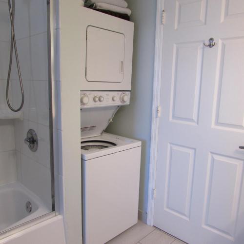 a washing machine in a bathroom next to a door at Edison Beach House in Fort Myers Beach