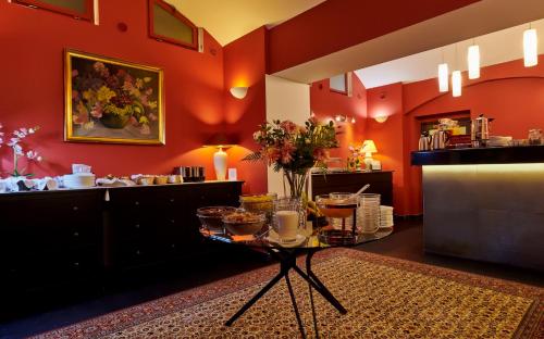 a room with red walls and a table with food at La Boutique in Prague