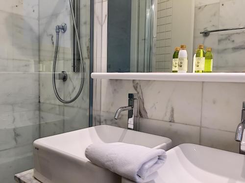une salle de bain blanche avec une douche et un lavabo dans l'établissement Nestor&Jeeves - PALAIS DE FRANCE - Central - Sea front, à Nice