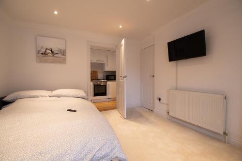 a bedroom with a bed and a flat screen tv at Wakeford Cottage in Worthing