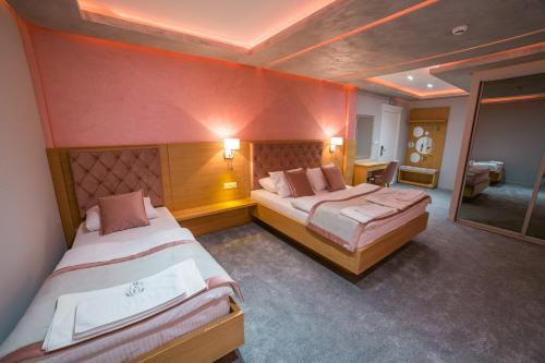 a hotel room with two beds and a mirror at Motel Felikitas in Laktaši