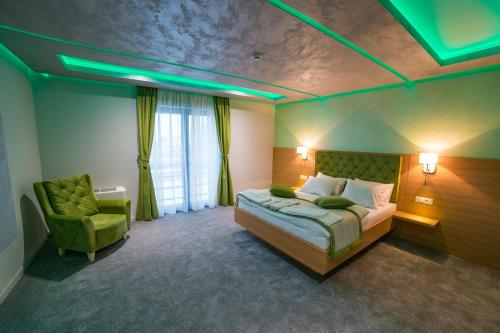 a bedroom with a bed and a green ceiling at Motel Felikitas in Laktaši