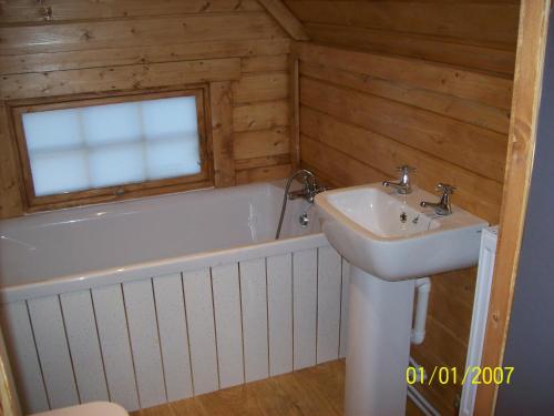 y baño con bañera y lavamanos. en The Hobbit House, en Fort William
