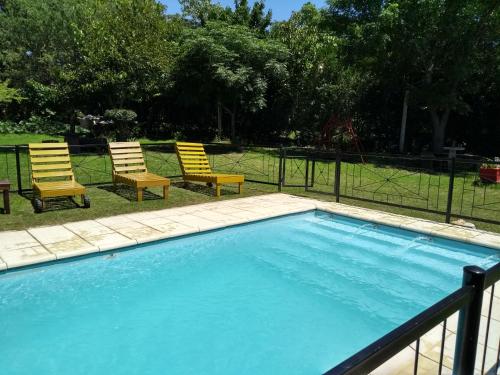 een zwembad met twee stoelen en een hek bij Cabañas Brisas Del Mirador in Bialet Massé