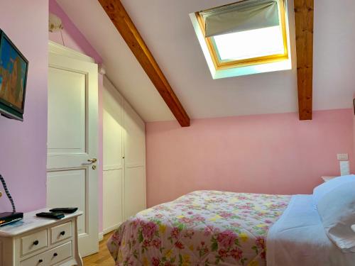 a bedroom with pink walls and a bed and a window at The Secret Garden Relais in Piano di Sorrento