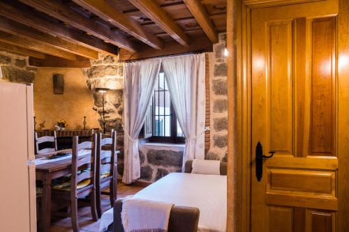 a kitchen and dining room with a table and a room with a dining room at El Mirador del Alberche in Navaluenga