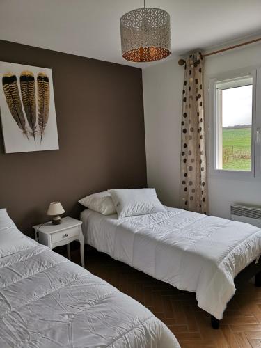 une chambre avec deux lits et une fenêtre dans l'établissement Au Clos des Bulles Champenoises, à Morangis
