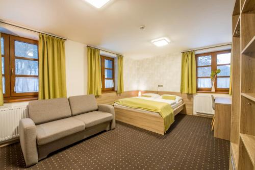 1 dormitorio con 1 cama y 1 sofá en Restaurace a Penzion Bludoveček, en Bludov
