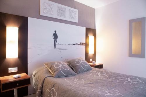 a bedroom with a bed with a picture of a man on a beach at Résidence Les Flamants Roses in Canet-en-Roussillon