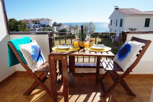 einen Tisch und Stühle auf einem Balkon mit Meerblick in der Unterkunft Cala Balmins Sea View in Sitges