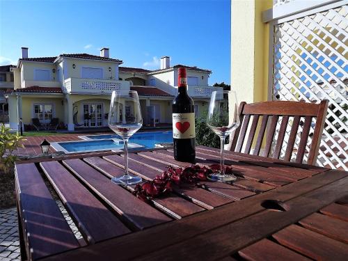カザル・ダ・ラゴア・セッカにあるProman Holidaysの木製テーブルにワイン1本とグラス2杯