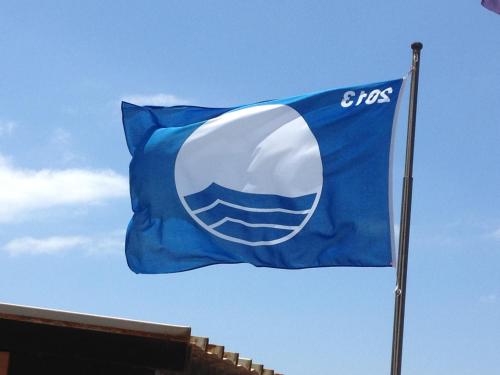 a blue and white flag with the gas logo on it at Villaggio Mare Si in Follonica