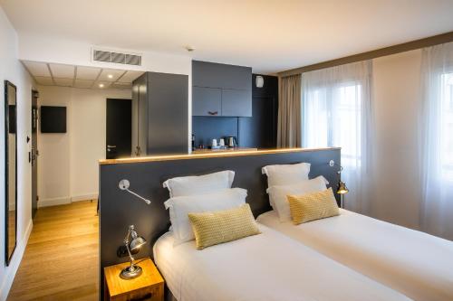 Cette chambre comprend un lit avec deux oreillers. dans l'établissement Best Western Plus Suitcase Paris La Défense, à Bois-Colombes