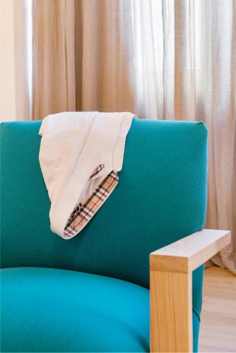 a blanket on the back of a blue couch at Maryflower Premium Apartments Piraeus in Piraeus