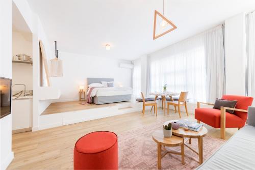 - un salon avec un lit, une table et des chaises dans l'établissement Maryflower Premium Apartments Piraeus, au Pirée
