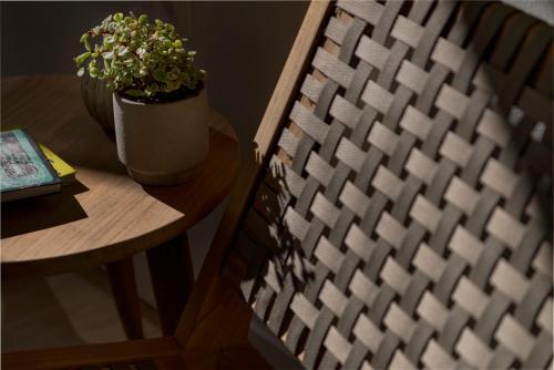 a chair next to a table with a potted plant at Maryflower Premium Apartments Piraeus in Piraeus