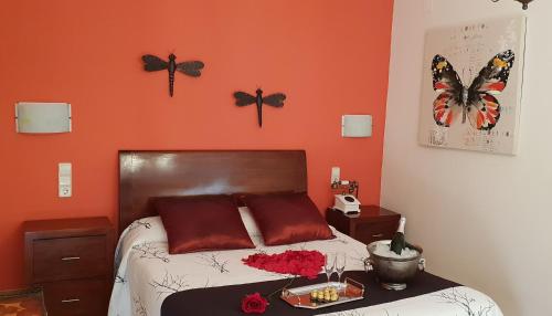 a bedroom with a bed with butterflies on the wall at Hotel Iris La Eliana in La Eliana