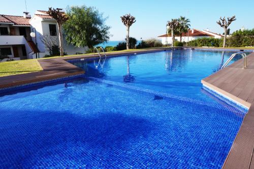 a large swimming pool with blue water at Cala Balmins Sea View in Sitges