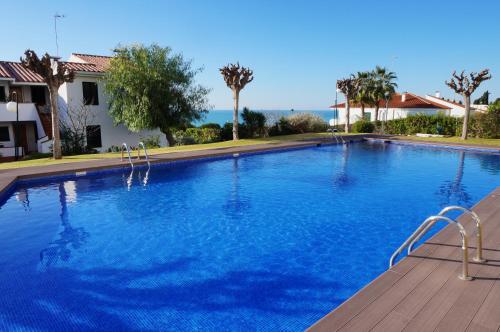 a large swimming pool with blue water at Cala Balmins Sea View in Sitges