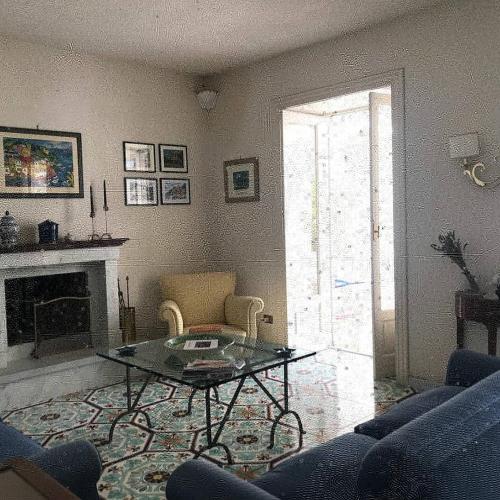 a living room with a coffee table and a fireplace at VILLA DEL MELOGRANO in Patti