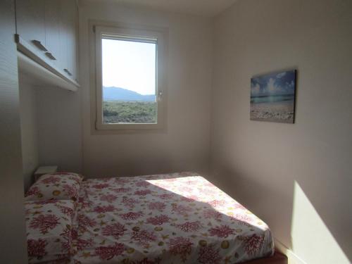 バデージにあるResidence con piscina Baia delle Mimoseのベッドルーム(ベッド1台、窓付)