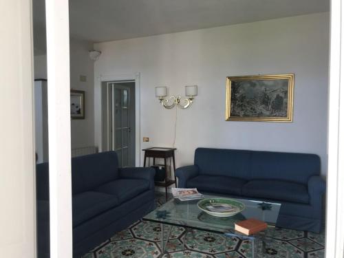 a living room with two blue couches and a table at VILLA DEL MELOGRANO in Patti