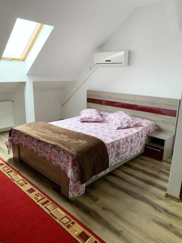 a bedroom with a bed and a red rug at Hotel Restaurant Enigma Plopeni in Plopeni