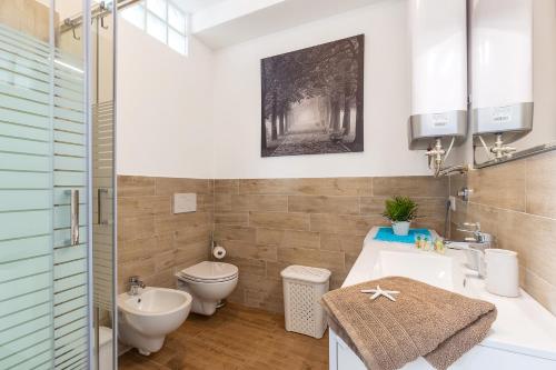 ein Bad mit einem WC und einem Waschbecken in der Unterkunft Casa Olivastro Vista Mare in Santa Maria Navarrese