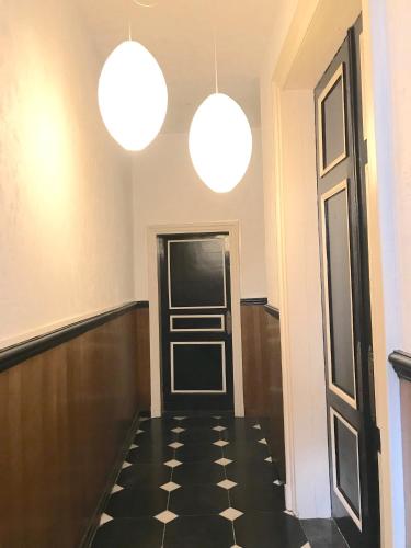 an empty hallway with two lights and a door at Gite Le Cerf Pantin in Saint-Hubert