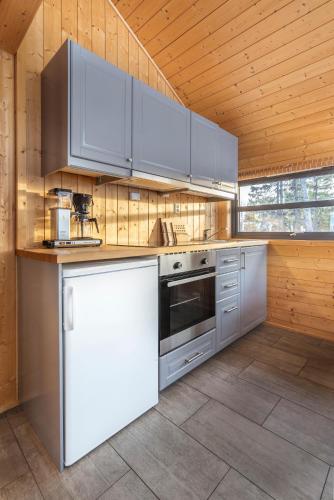 a kitchen with white appliances and a wooden ceiling at Liapark in Ål
