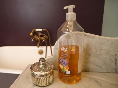a bottle of alcohol sitting on top of a bathroom counter at Nos chambres en ville B&B in Lyon