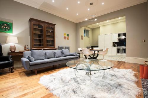 ein Wohnzimmer mit einem Sofa und einem Tisch in der Unterkunft Apartment 1 The Grove in Durham