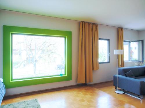 a living room with a green window and a couch at Künstlerhaus Arthotel in Geislingen