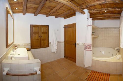 a bathroom with a tub and a sink and a bath tub at Can Vich Petit in Sant Carles de Peralta