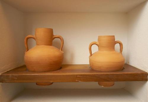 two vases sitting on a wooden shelf at Can Vich Petit in Sant Carles de Peralta