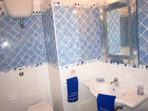 a blue and white bathroom with a sink and a mirror at Le Case dei Pescatori - La Suite in Ponza