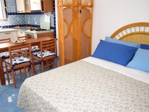 a bedroom with a bed and a table and a kitchen at Le Case dei Pescatori - La Suite in Ponza